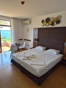 a hotel room with a large bed and a balcony at Guest Rooms Skalite in Sozopol
