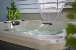 a bath tub filled with water with a faucet at Romantic beach house with jacuzzi in San Mauro a Mare