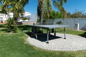 a ping pong table sitting on a brick patio at Quinta do Pedro in Luz de Tavira