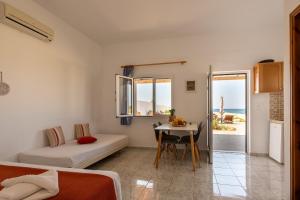 a room with a bed and a table with a tableablish at Sandy Steps Beachfront Apartments in Malia