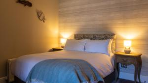 a bedroom with a bed with two lamps on tables at The Plough in Alnwick