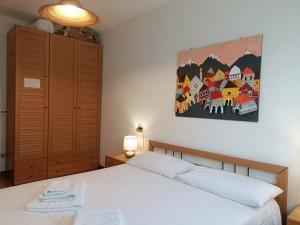 a bedroom with a bed and a painting on the wall at Mountain Haven Free parking in Temù