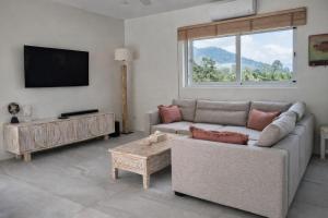 a living room with a couch and a tv at Jungle Home in Koh Samui