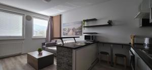 a kitchen and living room with a counter top in a room at Apartmán STATION Vrútky centrum in Vrútky