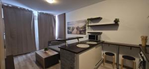 a kitchen with a counter and chairs in a room at Apartmán STATION Vrútky centrum in Vrútky +2 photos