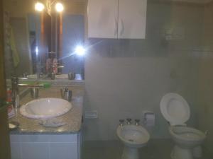 una persona che scatta una foto di un bagno con servizi igienici e lavandino di Casa soñada con vista a la Sierra de los Comechingones a Merlo Altre 38 foto