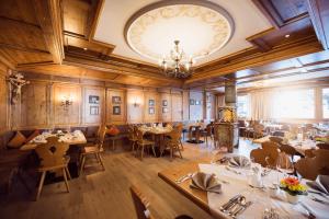 a restaurant with tables and chairs and a chandelier at Premium Activehotel Bergkönig in Neustift im Stubaital +115 photos