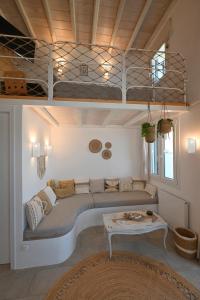 a living room with a couch and a bunk bed at Molos Tinos Cycladic house in Panormos