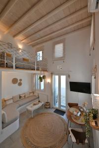 a living room with a couch and bunk beds at Molos Tinos Cycladic house in Panormos