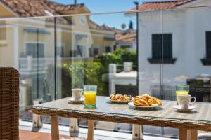 a table with a plate of food and two glasses of orange juice at WonderStays Villa Lucía in Málaga