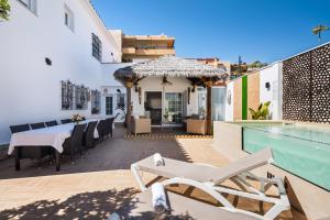 a patio with a table and a swimming pool at WonderStays Villa Lucía in Málaga
