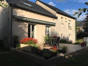 a house with flowers and plants in front of it at Chambres Du Bois Des Hâtes in Saint-Avertin