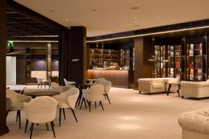a lobby with tables and chairs and a library at Emily Resort in Lviv