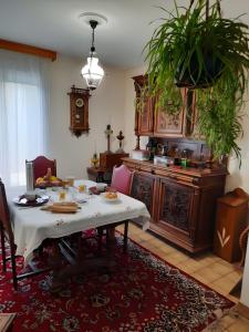 a dining room with a table and a kitchen with a clock at Chambres Du Bois Des Hâtes in Saint-Avertin