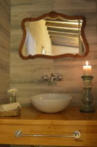 W łazience znajduje się umywalka, lustro i świeca. w obiekcie La Caballeriza Posada Boutique w mieście San Rafael