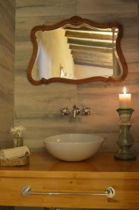 a bathroom with a sink and a mirror and a candle at La Caballeriza Posada Boutique in San Rafael