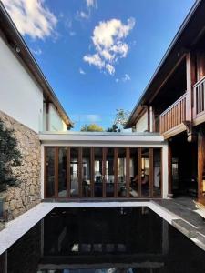 an external view of a house with a pool at PURE Hotel Lijiang in Lijiang