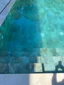a shadow of a person standing in a swimming pool at Azure Pool Villa in Lalzit Bay +4 photos