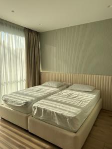 a bedroom with two beds and a window at Azure Pool Villa in Lalzit Bay