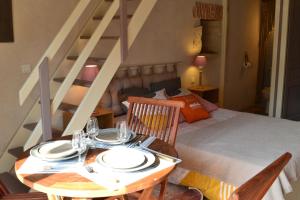 a room with a table with plates on it with a bed at Tamaris in La Jarrie +12 photos