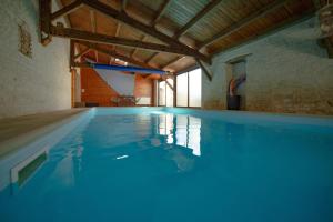 a swimming pool with blue water in a building at Tamaris in La Jarrie