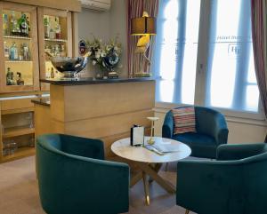 Ein Zimmer mit zwei blauen Stühlen, einem Tisch und einer Theke in der Unterkunft Hôtel Burgevin in Sully-sur-Loire