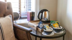 a table with a coffee maker and two cups on it at The Plough in Alnwick