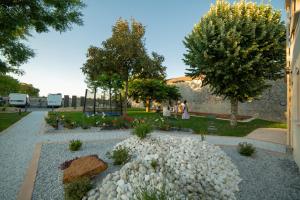 a garden with white rocks and trees and a building at Trémière et cabane in La Jarrie