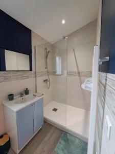 a white bathroom with a shower and a sink at Trémière et cabane in La Jarrie +17 photos