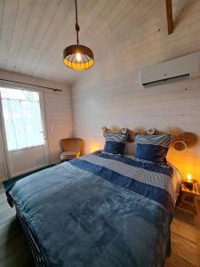 a bedroom with a large bed with a blue comforter at Trémière et cabane in La Jarrie