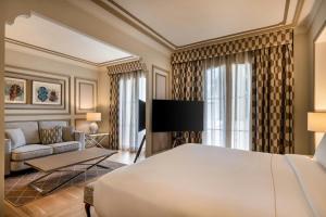 a hotel room with a bed and a couch at Grand Hotel Las Dunas, Autograph Collection in Estepona