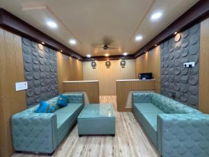 a waiting room with two blue couches and a table at S K Tower Hotels in Nawāda