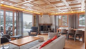 a living room with a couch and a table at Luxurious Flat with Jacuzzi Sauna in Schönried