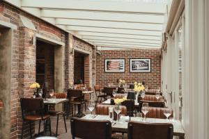 a restaurant with tables and chairs and a brick wall at Winemaker's Pub in Goudhurst