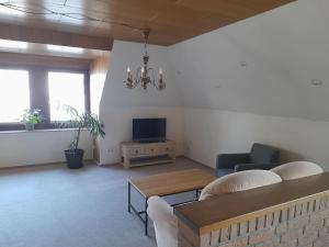 a living room with a couch and a tv at Eichhörnchen, Ferienwohnung in Schneverdingen