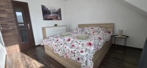 a bedroom with a bed with a floral bedspread at Apartmán STATION Vrútky centrum in Vrútky