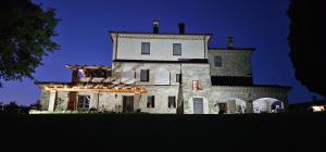 an old castle with a lit up facade at night at Poggio Cortese in Todi