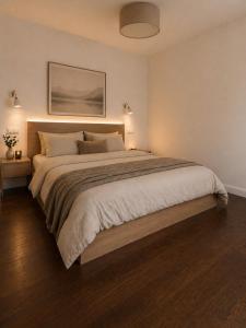 a bedroom with a large bed and a painting on the wall at Lux Apartments in Lichtenfels