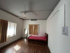 a bedroom with a red bed in a room with a window at Leos Inn in Pune