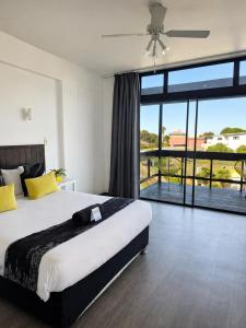 a bedroom with a large bed and a large window at Hoedjiesbaai Hotel in Saldanha