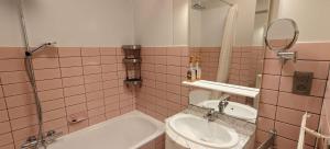 a bathroom with a tub and a sink and a mirror at Zeezicht Studio Alisa in Blankenberge