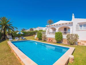 a villa with a swimming pool in front of a house at Villa BiniRe by 3VILLAS in Binibeca