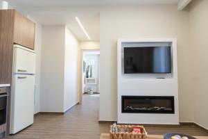 a living room with a fireplace and a flat screen tv at Antaia 2 in Nafplio