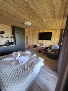 a bedroom with a large bed and a living room at Makárlux Vendégház in Pécs