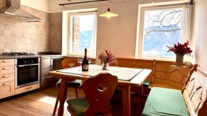 a kitchen with a table with a bottle of wine on it at Villa ai noci in Carano