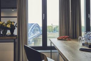 a room with a table with a view of a bridge at The Bridge Suites Hotel in Krakow