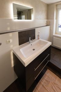 a bathroom with a white sink and a mirror at Ferienwohnung Tietze in Fockendorf +12 photos