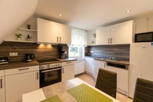 a kitchen with white cabinets and a table in it at Ferienwohnung Tietze in Fockendorf