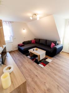 a living room with a black couch and a table at Ferienwohnung Tietze in Fockendorf
