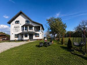 a large white house on a grassy yard at A&D House in Novaci-Străini